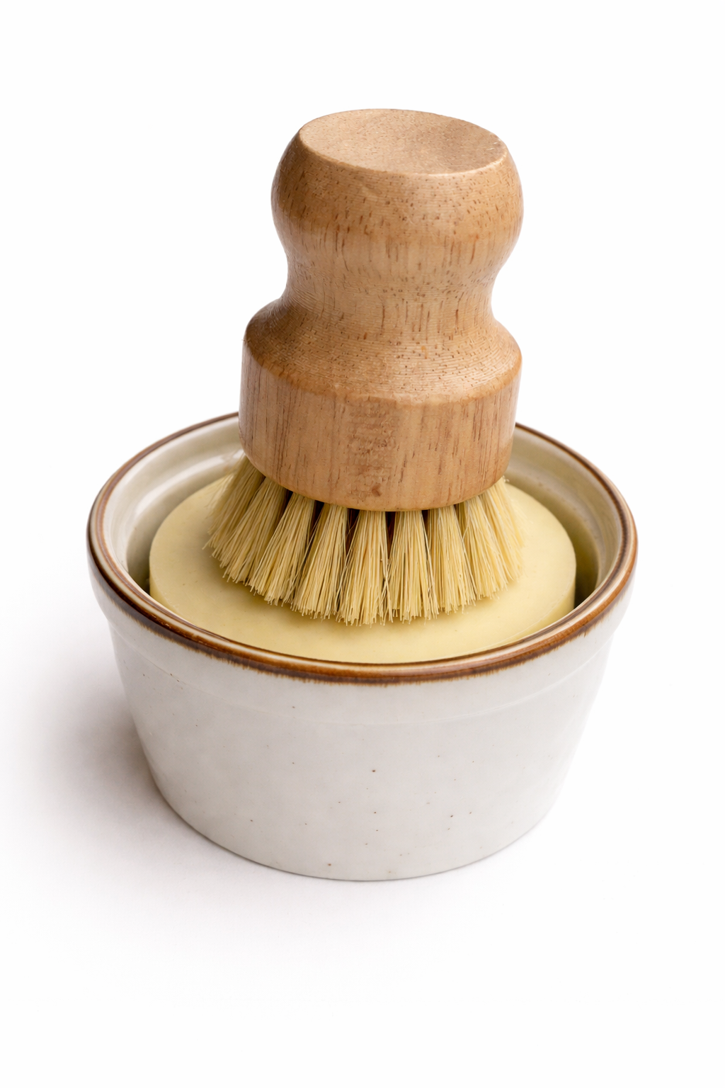 Ensemble à vaisselle comprenant une brosse de bois sur un savon à vaisselle solide qui est dans un ramequin de céramique.  