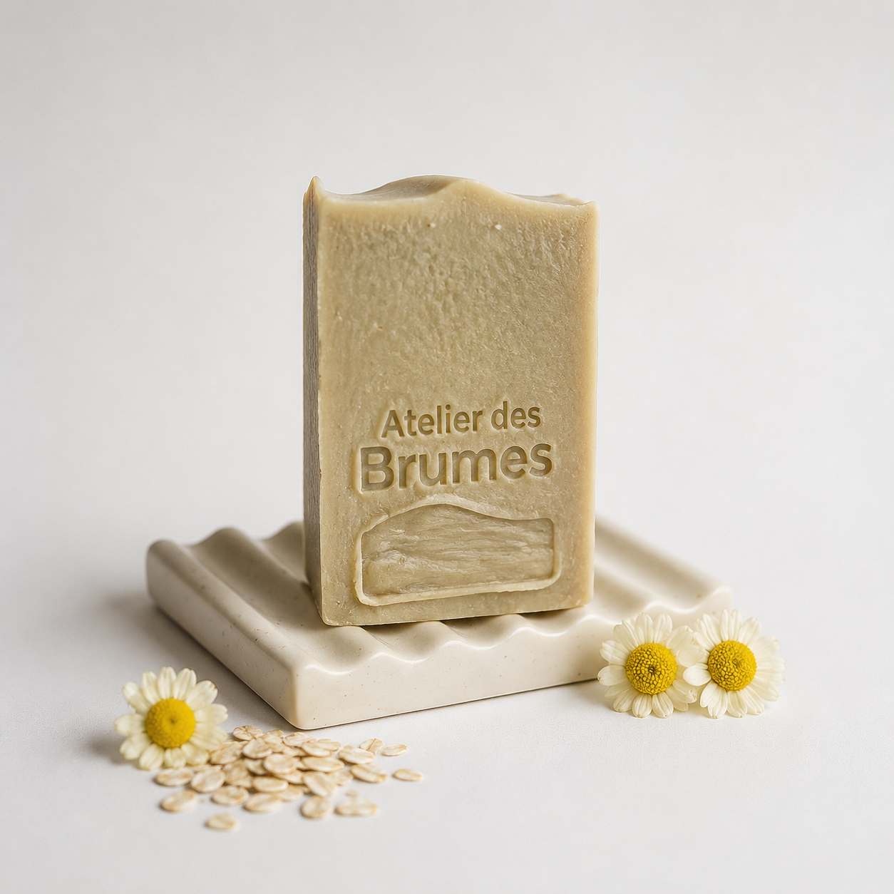 savon rectangulaire beige sur porte savon près de flocons d'avoine et de fleurs de camomille