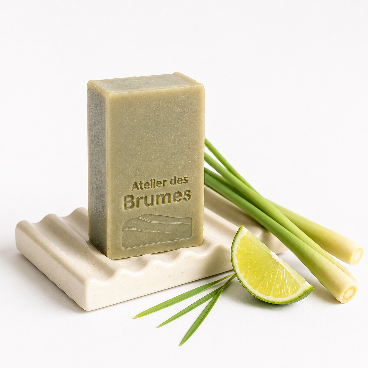 Savon rectangulaire kaki sur un porte savon avec un quartier de lime et tiges de citronnelle