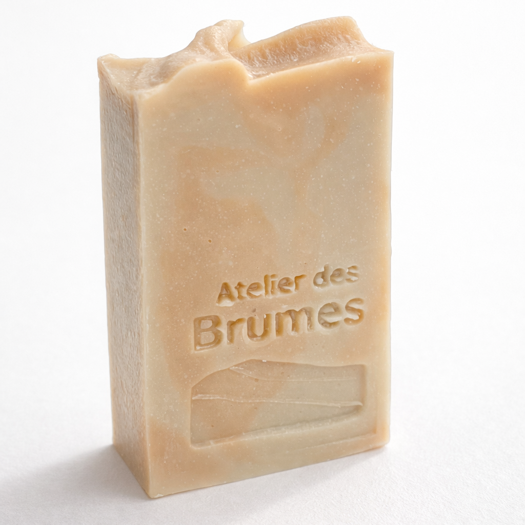 Savon rectangulaire marbré beige et rosé, avec le logo Atelier des Brumes en relief, vu de profil sur fond blanc