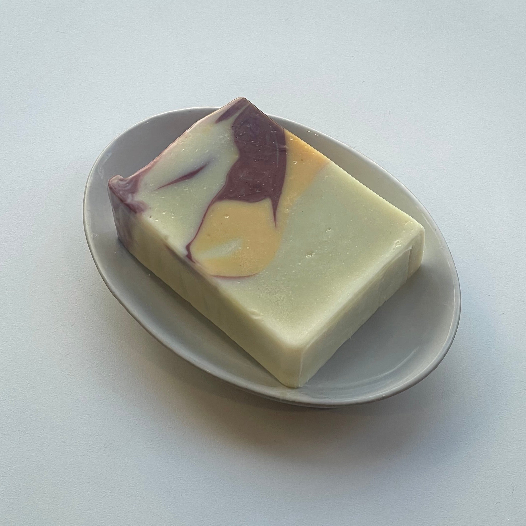 savon rectangulaire vert, jaune et rouge sur un porte-savon 